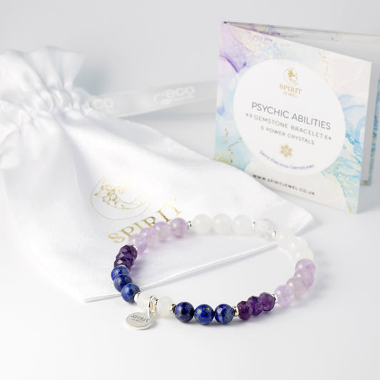 a bracelet with a charm and a box of spiritual jewelry, including a bracelet made of gemstones and crystals.