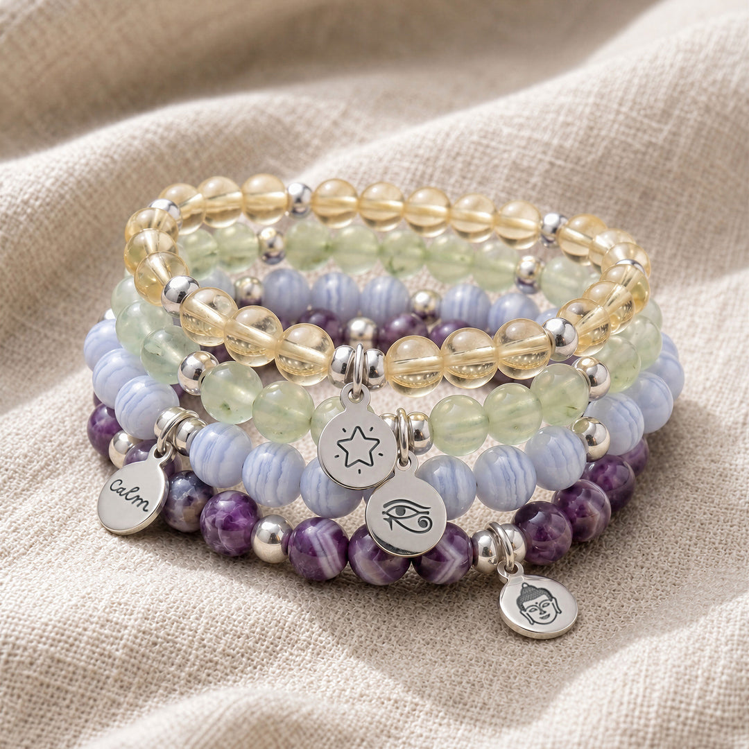 A stack of four personalised crystal gemstone bracelets — Prehnite, Lemon Quartz, Blue Lace Agate, and Amethyst Chevron