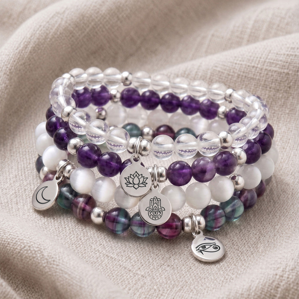 A stack of four personalised crystal gemstone bracelets — Clear Quartz, Amethyst, Selenite, and Fluorite
