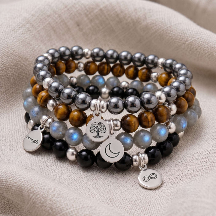 A stack of four personalised crystal gemstone bracelets — Hematite, Tiger&