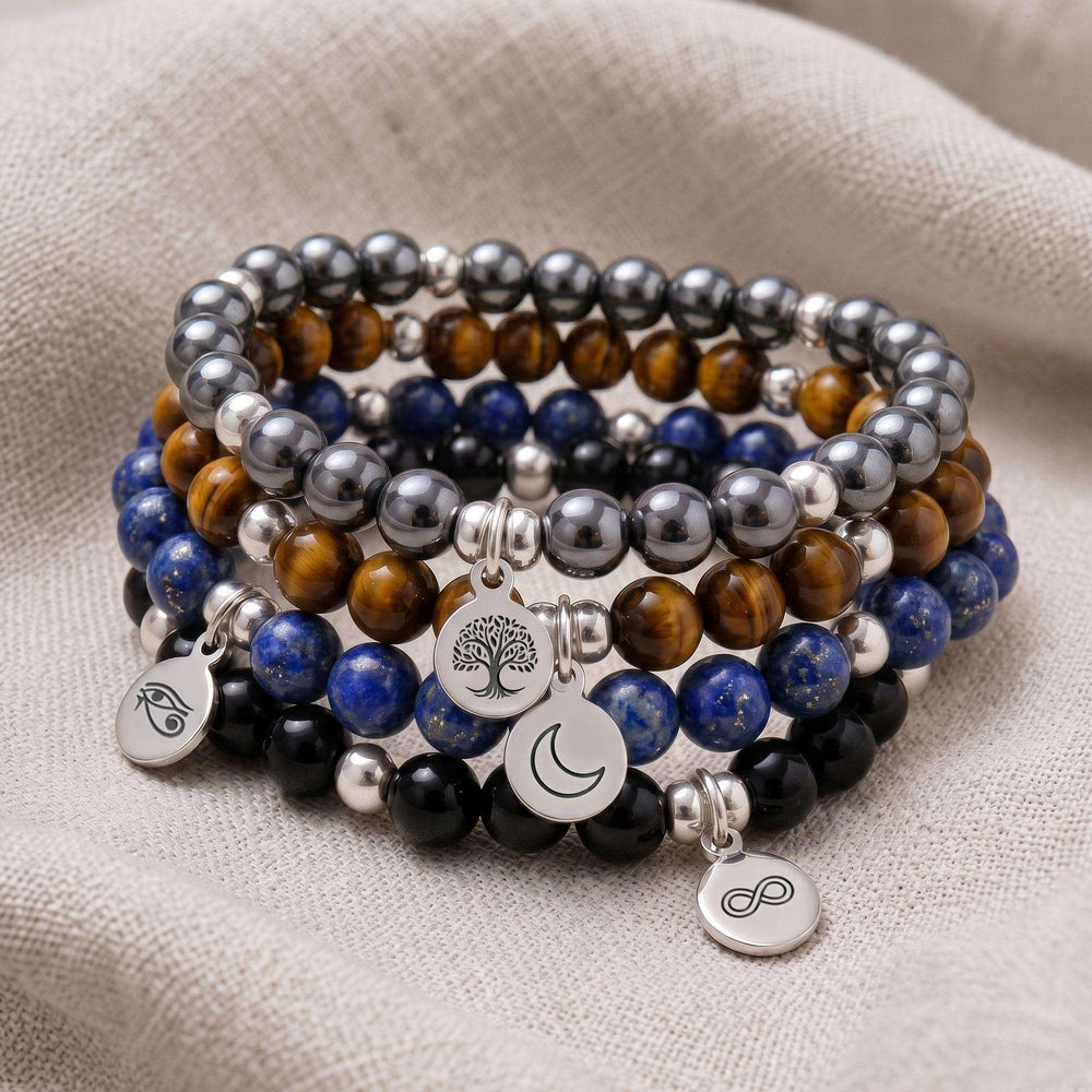 A stack of four personalised crystal gemstone bracelets — Lapis Lazuli, Hematite, Tiger's Eye, and Black Tourmaline