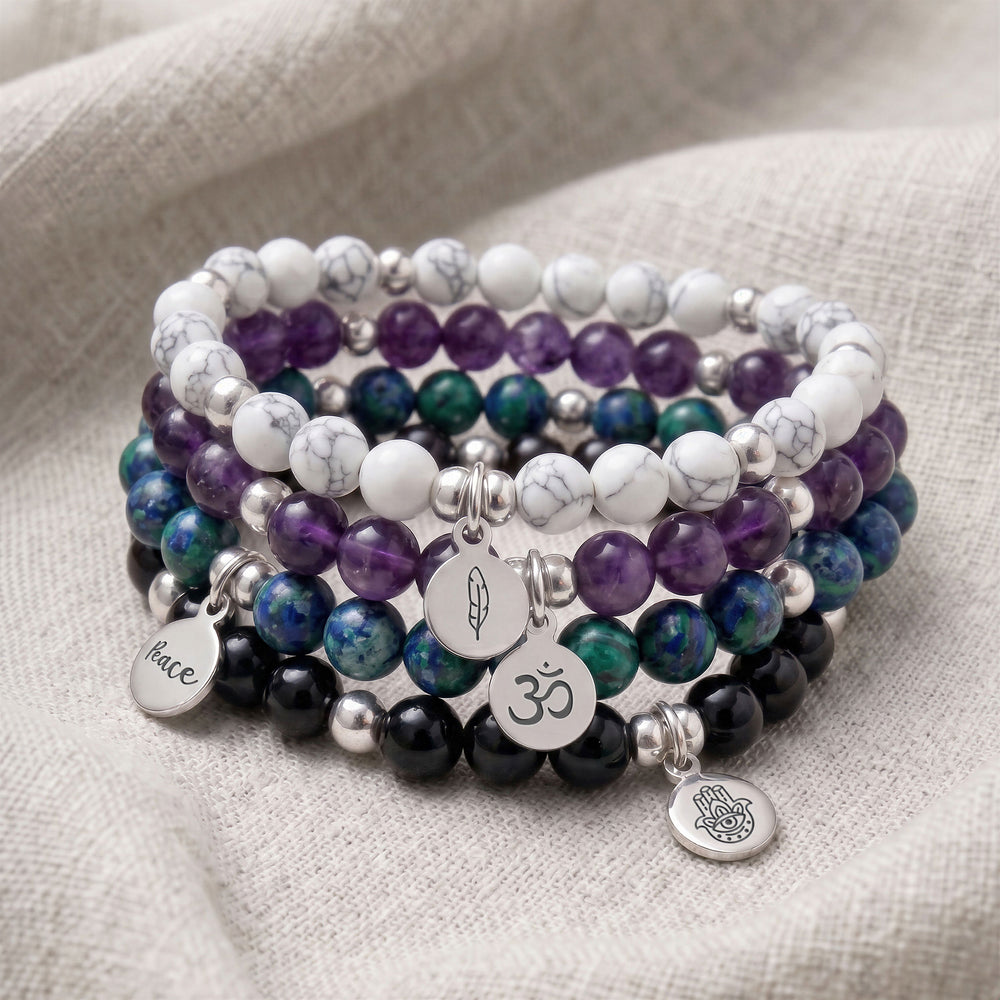 A stack of four personalised crystal gemstone bracelets — Azurite, Howlite, Amethyst, and Black Tourmaline
