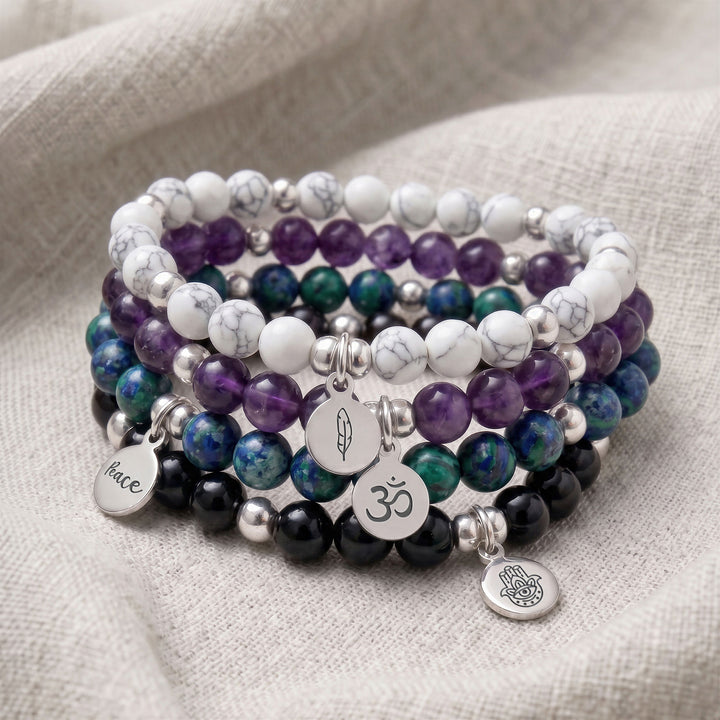 A stack of four personalised crystal gemstone bracelets — Azurite, Howlite, Amethyst, and Black Tourmaline