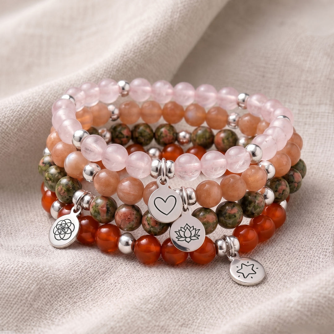 A stack of four personalised crystal gemstone bracelets — Carnelian, Rose Quartz, Peach Moonstone, and Unakite