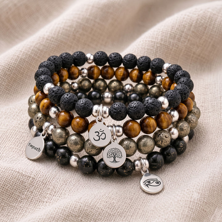 A stack of four personalised crystal gemstone bracelets — Shungite, Lava Rock, Tiger&