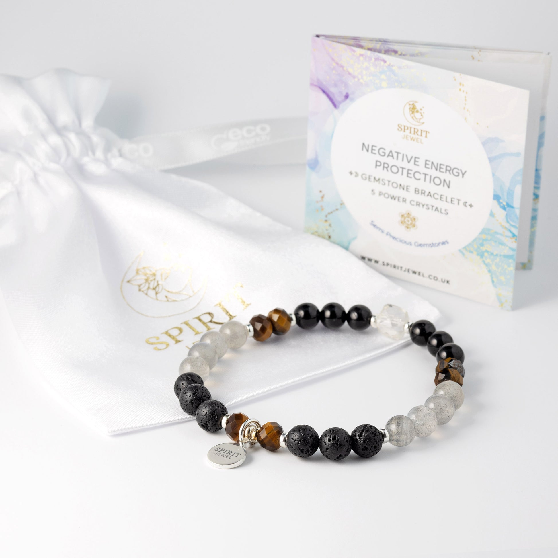 a bracelet with various colored beads, including black, gray, and brown, as well as a white bag with a gold logo and text.