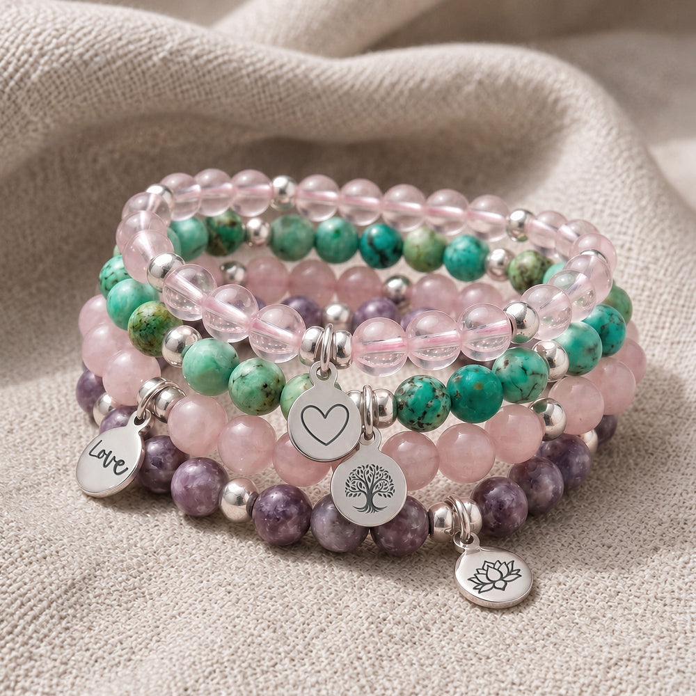 A stack of four personalised crystal gemstone bracelets — Rose Quartz, AAA Rose Quartz, Chrysocolla, and Lepidolite